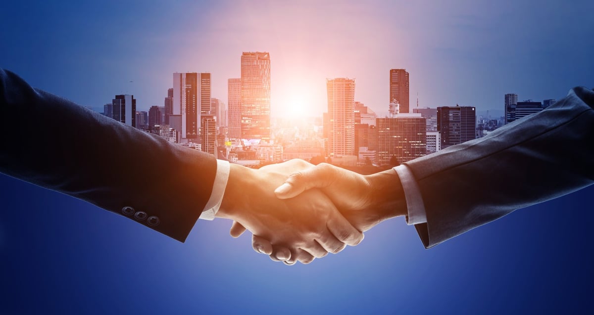 Business leaders shaking hands on a government partnership