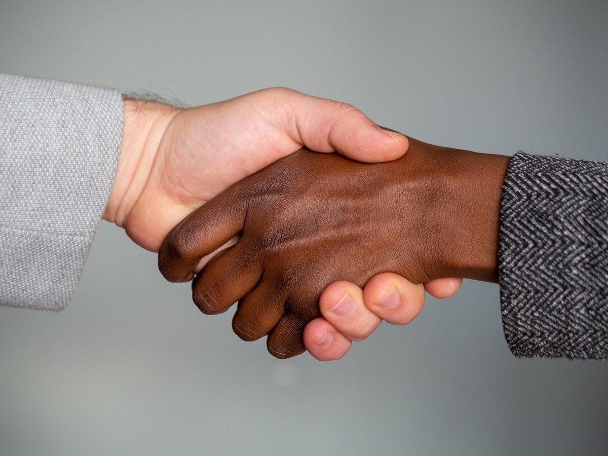 International business agreement handshake across a table